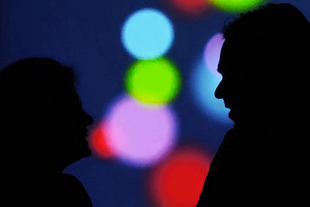 couple in silhouette talking on a colorful background